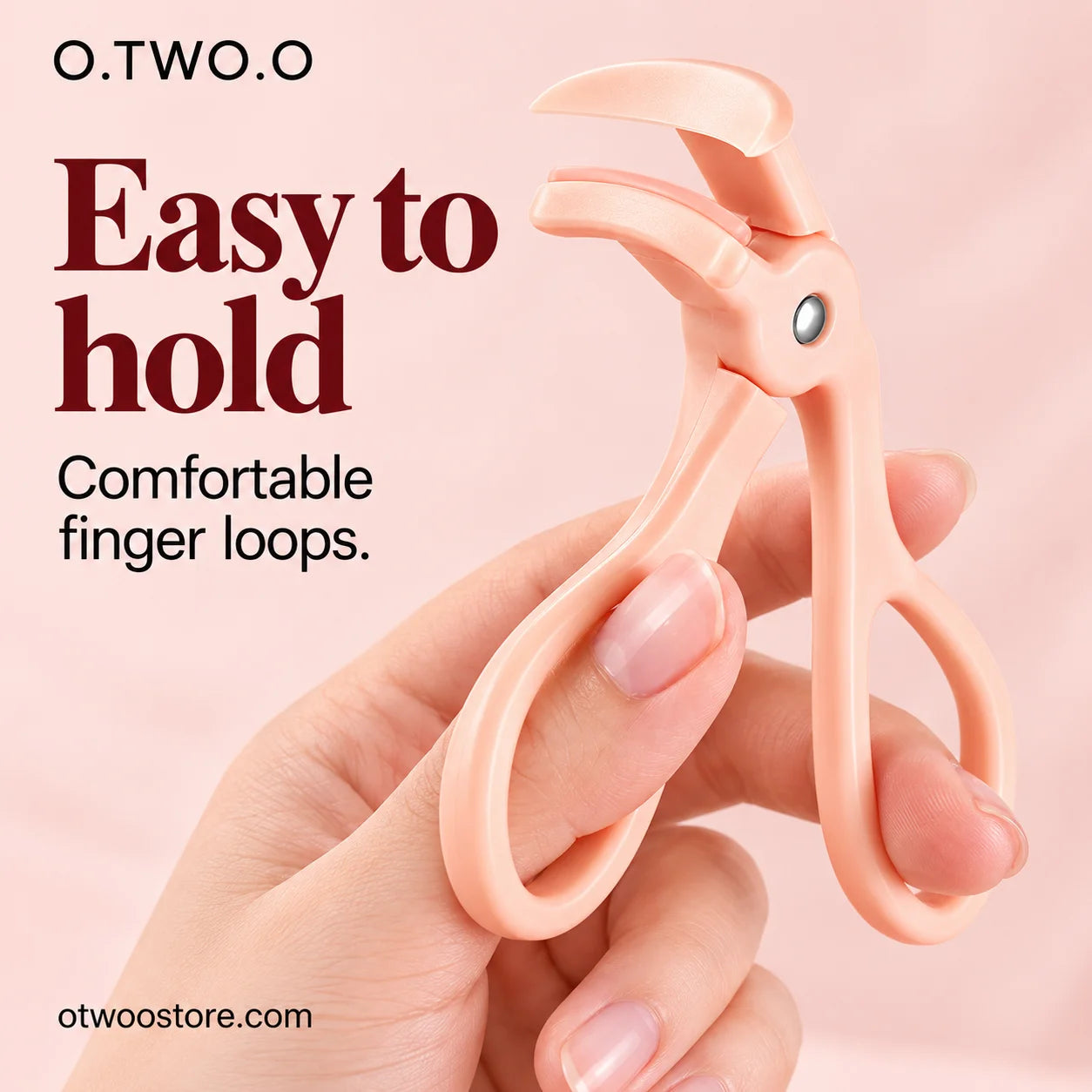 Peach eyelash curler held by comfortable rounded finger loops